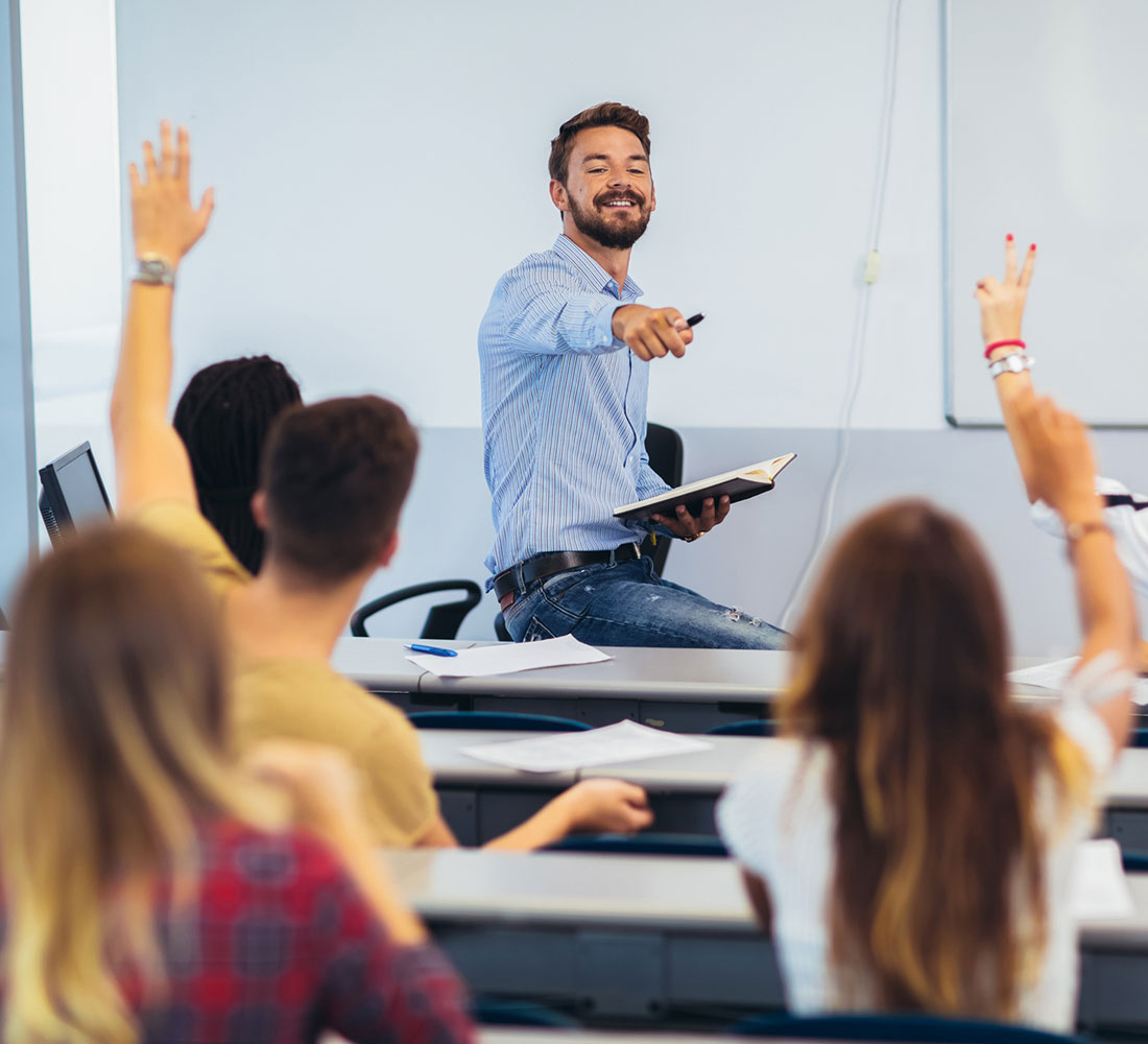 Male teacher having discussion with students in class